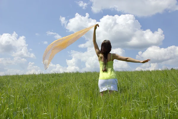 Hermosa mujer en campo de hierba verde y cielo nublado —  Fotos de Stock