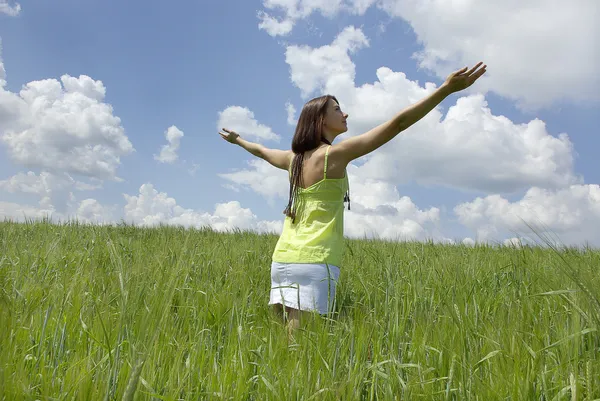 Bella donna nel campo di erba verde e cielo nuvola — Foto Stock