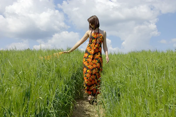 Bella donna nel campo di erba verde e cielo nuvola — Foto Stock