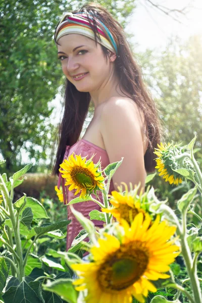 Mädchen auf dem Feld mit Sonnenblumen — Stockfoto
