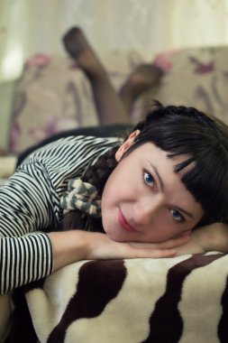 mavi gözlü bir kız kanepede yatıyor.