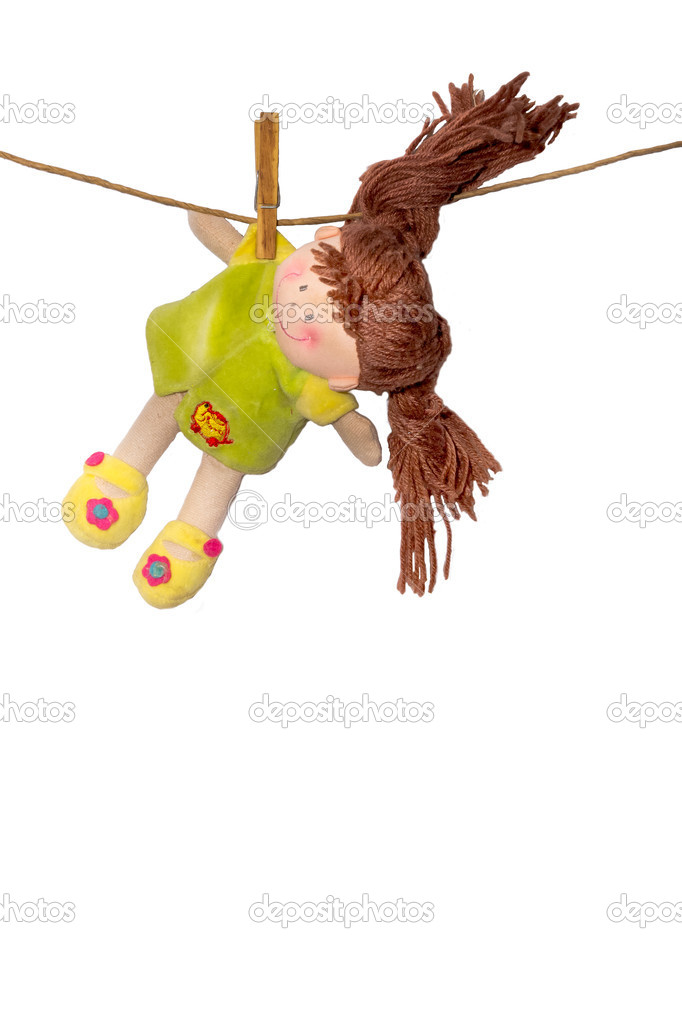 A soft doll dries on a linen rope