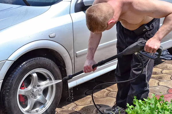 Een man wast de auto. — Stockfoto