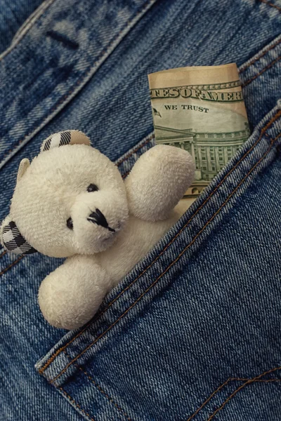 Bolso de jeans com brinquedo de criança e dinheiro — Fotografia de Stock