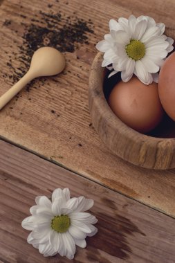 yumurta ve ahşap arka plan üzerinde papatya