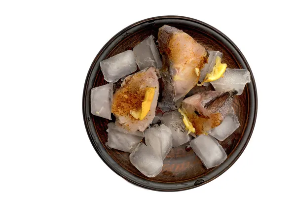 Сиру рибу нарізають скибочками з приправами в льоду — стокове фото
