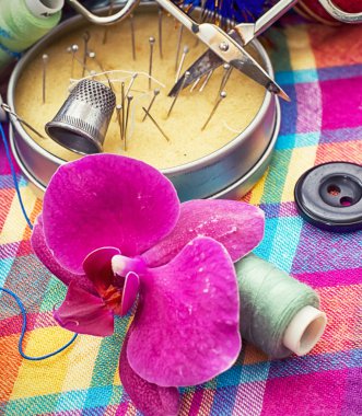 iplik ve iğne arka planda orkide çiçek