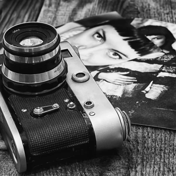 Old film camera on a background of old girls photos — Stock Photo, Image