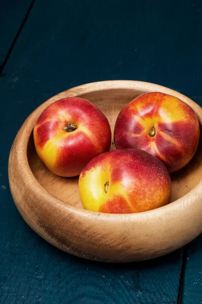 Peach bowl on wooden background — Stock Photo, Image