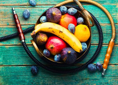 İncir, mango, muz ve erik tadında nargile içmek. Meyve aromalı tütün nargilesi..