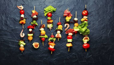 Açık büfe karides, jamon, meyve ve sebzeler. Bambu şiş üzerinde taze yaz meyveli atıştırmalıklar.