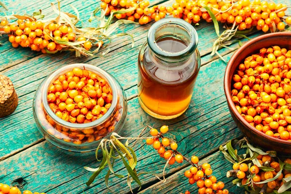 Natural tincture of fresh sea buckthorn berries. Herbal medicine and homeopathy