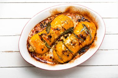 Adaçayı, kekik ve sarımsakla kızartılmış sonbahar balkabağı. Tabakta otlarla pişirilmiş balkabağı.