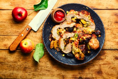 Fırında domuz eti, hurma, elma ve fıstık. Kırsal ahşap masada kızarmış domuz eti.