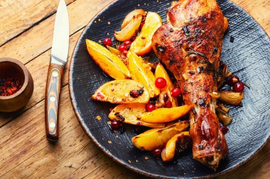 Portakalla pişirilmiş hindi eti. Kırsal ahşap masada kızarmış hindi budu.