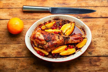 Portakalla pişirilmiş hindi eti. Kırsal ahşap masada kızarmış hindi budu.