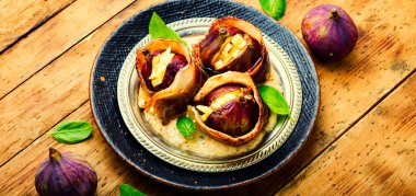 Keçi peyniri ile doldurulmuş domuz pastırmasına sarılı incirler.