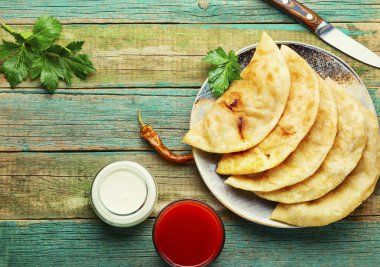 Chebureks hamur mayası yapıyor, kıyma dolduruyor.