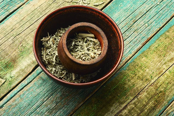 Dried wormwood in a bowl, homeopathic herbs in herbal medicine.