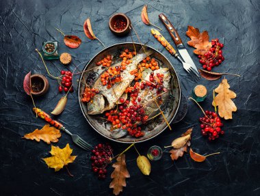 Enfes kızarmış dorado balığı ve sonbahar viburum berryleri.