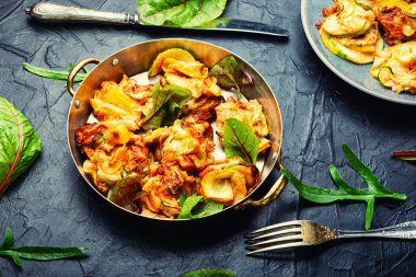 Kızarmış kabak ve taze bitkiler tabakta.