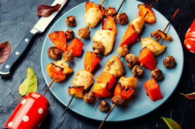 Mantarlı tavuk filetosu ve ahşap şişte balkabağı. Izgara et ve sebze.