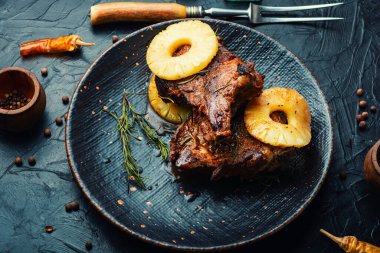 Tabağında ananas olan ızgara biftek.