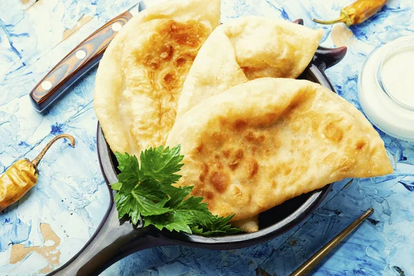 Cheburekler, et dolu kızarmış hilal şeklinde kekler. Ev yapımı kızarmış cheburek turtaları.