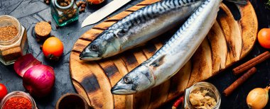 Mutfak masasında çiğ uskumru balığı ve baharat var. Deniz ürünleri.