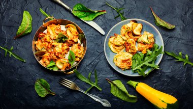 Kızarmış kabak ve taze bitkiler tabakta.