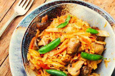 Mantar ve havuçla pişirilmiş lezzetli lahana. Yemeği ödünç al..