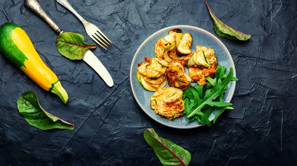 Kızarmış kabak ve taze bitkiler tabakta.