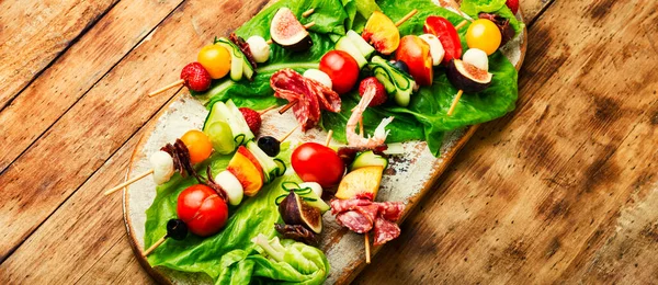 Karides, jamon, ahşap şiş üzerinde meyve ve sebze ziyafeti..