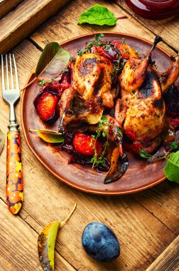 Kırsal ahşap masada erik soslu bıldırcın kızartması. Erikle doldurulmuş et bıldırcını..