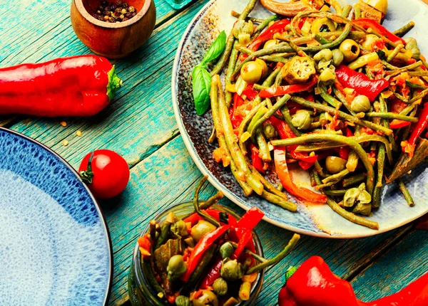 Biber, kuşkonmaz, fasulye, domates ve kapariden yapılan baharatlı sebze aperatifi.