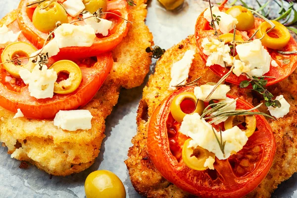 Thin layer of meat, breaded in breadcrumbs with cheese, olives and tomato. Meat dish - schnitzel