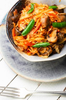 Mantar ve havuçla pişirilmiş lezzetli lahana. Yemeği ödünç al..