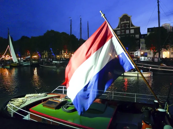 Drapeau néerlandais flottant sur un bateau à vapeur la nuit — Photo