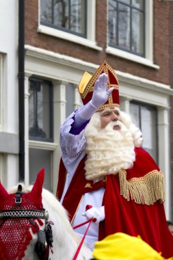 Saint nicolaas sokaklarında sürme beyaz atının üstünde