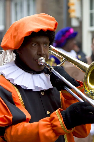 Zwarte Piet playing trombone. He is a helper of Dutch Saint Nico — Stock Photo, Image