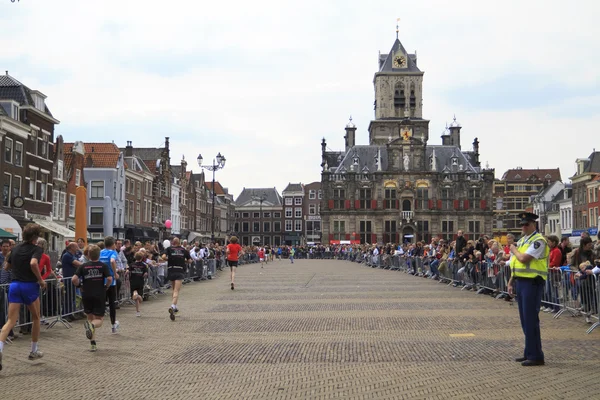 Coureurs passant l'hôtel de ville dans l'historique Delft — Photo