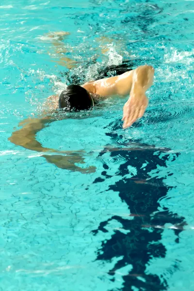 Mand svømmer i swimmingpool - Stock-foto