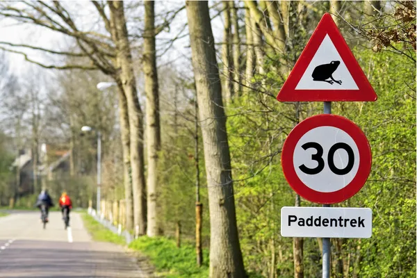 Yol işaretleri ile arka planda bisikletçiler — Stok fotoğraf