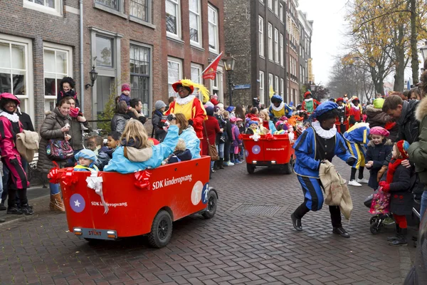 Kinder in Karren eskortiert von Zwarte Piet — Stockfoto