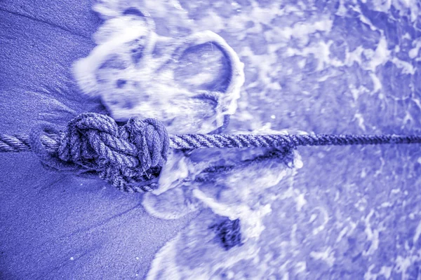 Корабельный верёвочный узел на тропическом пляже с приливными волнами в PANTONE 17-3938 — стоковое фото