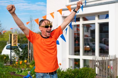 Hollandalı Hollandalı, Hollanda 'da turuncu giyinmiş bir sokak partisi sırasında yolda kralları kutluyor. Koningsdag, Hollanda kraliyet ailesini kutlamak için düzenlenen geleneksel bir festivaldir. Hollanda bayrağı ve evleri süsleme.