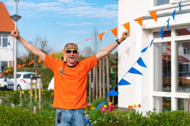 Hollandalı Hollandalı, Hollanda 'da turuncu giyinmiş bir sokak partisi sırasında yolda kralları kutluyor. Koningsdag, Hollanda kraliyet ailesini kutlamak için düzenlenen geleneksel bir festivaldir. Hollanda bayrağı ve evleri süsleme.