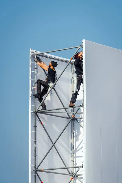 Arbeiter klettern auf Baugerüst — Stockfoto