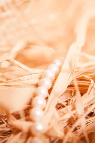 Christmas background with pearl and straw in gold color — Stock Photo, Image