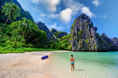 Matinloc Adası, El Nido, Palawan, Filipinler 'deki Saklı Plajda Kız - Cennet lagünü ve tropikal manzaradaki plaj